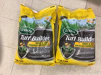 Two large yellow bags of Scotts Turf Builder Weed & Feed Herbicide, prominently displaying branding and usage information.