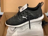 Side view of black Puma Ignite NXT men's running shoe with laces, showing knit upper and white midsole with Ignite text.