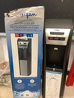 Box for Culligan bottom-load convertible water cooler with UV logo, shows box damage