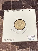 Front side of the 1927 Australian 3 Pence silver coin showing the Australian coat of arms inside protective holder.
