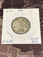 Front side of 1930 Canadian 25 cent coin showing denomination and maple leaf wreath.