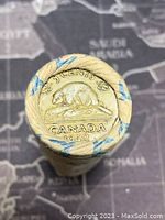 Close-up of the roll end showing imprint of 1942 Canadian 5 cents coin with beaver design and text