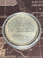 Photo of the reverse side of the coin showing two paddlers in a canoe with 'CANADA DOLLAR 1962' inscription.