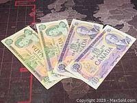 Four Canadian banknotes displayed, two $10 from 1971 and two $20 from 1979.