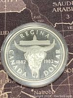 Reverse side of the 1982 Canada silver dollar coin featuring buffalo skull and building design.