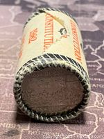 Rolled coins in original paper wrapper with partial visible design on the end.