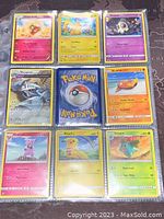 Nine Pokémon cards displayed in plastic sleeves, including Pikachu, Metagross, Granbull, Ivysaur, and Lotad among others.