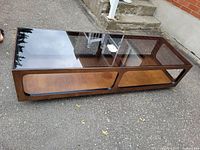 Perspective view showing entire table with glass top and wooden frame