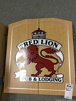 Closed wooden cabinet with lion crest and text 'The Red Lion Pub & Lodging.'