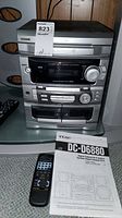 Photo of Teac DC-D6880 main stereo unit with remote control and instruction manual placed in front
