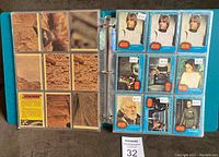 Open binder showing Star Wars trading cards with blue and red borders, featuring characters such as Luke Skywalker, Princess Leia, Darth Vader, and others. Cards are in plastic sleeves with price stickers.