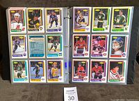 First photo showing two binder pages each holding nine hockey cards from the 1986-87 O.P.C. set, featuring players from teams like New Jersey Devils and Hartford Whalers.