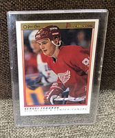Front of the 1990-91 OPC Premier Sergei Fedorov rookie card showing player in red Detroit Red Wings jersey, helmet and gloves, holding hockey stick, in plastic protective sleeve.