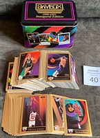 Photo showing a large stack of cards fanned out, showcasing many cards included in the complete set inside the collector's tin.