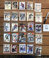 Top-down view of 25 NHL hockey cards arranged on a wooden surface, all signed in Sharpie, many in protective sleeves.