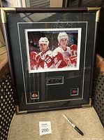 Framed photo showing both Steve Yzerman and Sergei Fedorov in uniform with the frame in full view, including the name plate and pins.