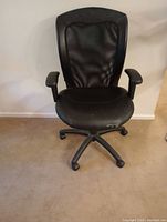 Front view of the black office chair showing the mesh back and seat damage.