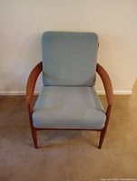Front view of lounge chair showing wood frame and blue-gray cushions