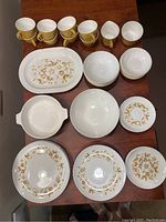 Full dish set displayed on table including plates, bowls, cups, and serving pieces showing the design and quantity of each item.