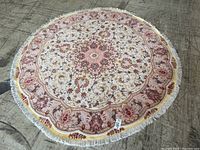 Full overhead view of round tapestry rug laid on concrete floor