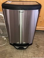 Front view of stainless steel garbage bin with black plastic lid and foot pedal.