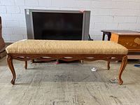Full view of upholstered hall bench showing wooden frame and patterned beige fabric.