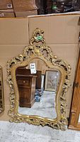 Full view of the ornate wood-framed mirror showing shape, size, and design details.