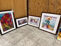 Group photo of four framed watercolor paintings arranged on floor against wooden wall.