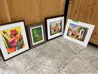 Four paintings arranged on wood floor showing two framed watercolours, one matted watercolour, and one framed oil painting