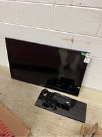 Samsung 40 inch flat-screen TV with stand and power cable shown against a wall.
