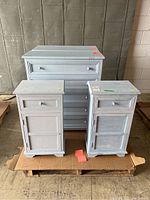 Overview of two small bedside tables and two larger dressers on pallet