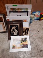 Grouped original watercolours and prints leaning against a wall showing various frame mats and art styles.