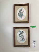 Two smaller bird prints each in wooden frames with oval mattes, mounted on wall