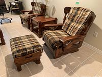 Wood rocking chair with plaid upholstered seat and back cushions alongside matching ottoman in similar plaid upholstery and wood frame, positioned on tiled floor in room with other wood furniture.