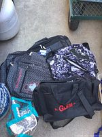 Photo showing three bags: gray Disney Mickey Mouse backpack, black and white Batman backpack, and black GLEIM bag.