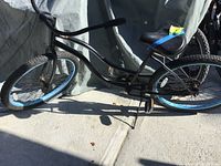 Full side view of black Aero Manhattan Beach ladies cruiser bike with blue rim tires