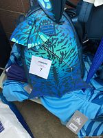 Close-up of a Disney Pandora-themed blue and turquoise backpack with leaf charms and umbrella charm