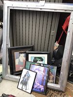 Two large metallic frames and six avant-garde framed pictures arranged leaning inside a large metallic frame, showing details of frames and imagery.