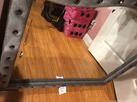 Full view of the large rectangular mirror showing the silver padded frame and floor reflection below.
