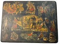 Top view of antique box decorated with Victorian era illustrated stickers showing various figures, animals and scenes.