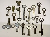 Overview of 18 assorted vintage and antique keys on white background.