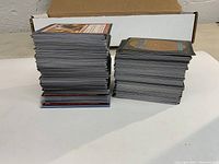 Two stacks of Magic The Gathering game cards totaling more than 450 cards, shown from the side to display the quantity.