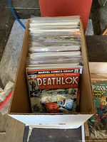 Top view of the box full of comic books showing "Deathlok the Demolisher" comic on top.