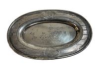 Top view of the small vintage sterling silver tray showing its oval shape and engraved decorative border.
