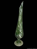 Side angle view of the tall green blown glass vase showing its elongated shape and marbling.