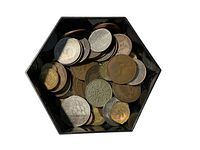 Top-down view of hexagonal container filled with assorted foreign coins showing various sizes and metals.