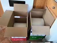 Two large rolls of bubble wrap in open cardboard boxes, showing top view of rolls and boxes.