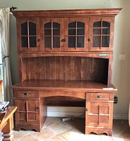 Front view of two-piece wood buffet and hutch, showing glass doors and drawers.