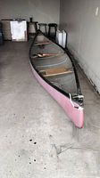 Full-length shot of pink hull fiberglass canoe and interior ribs