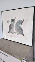 Frontal view of the framed print showing two stylized owls, black frame, matted.